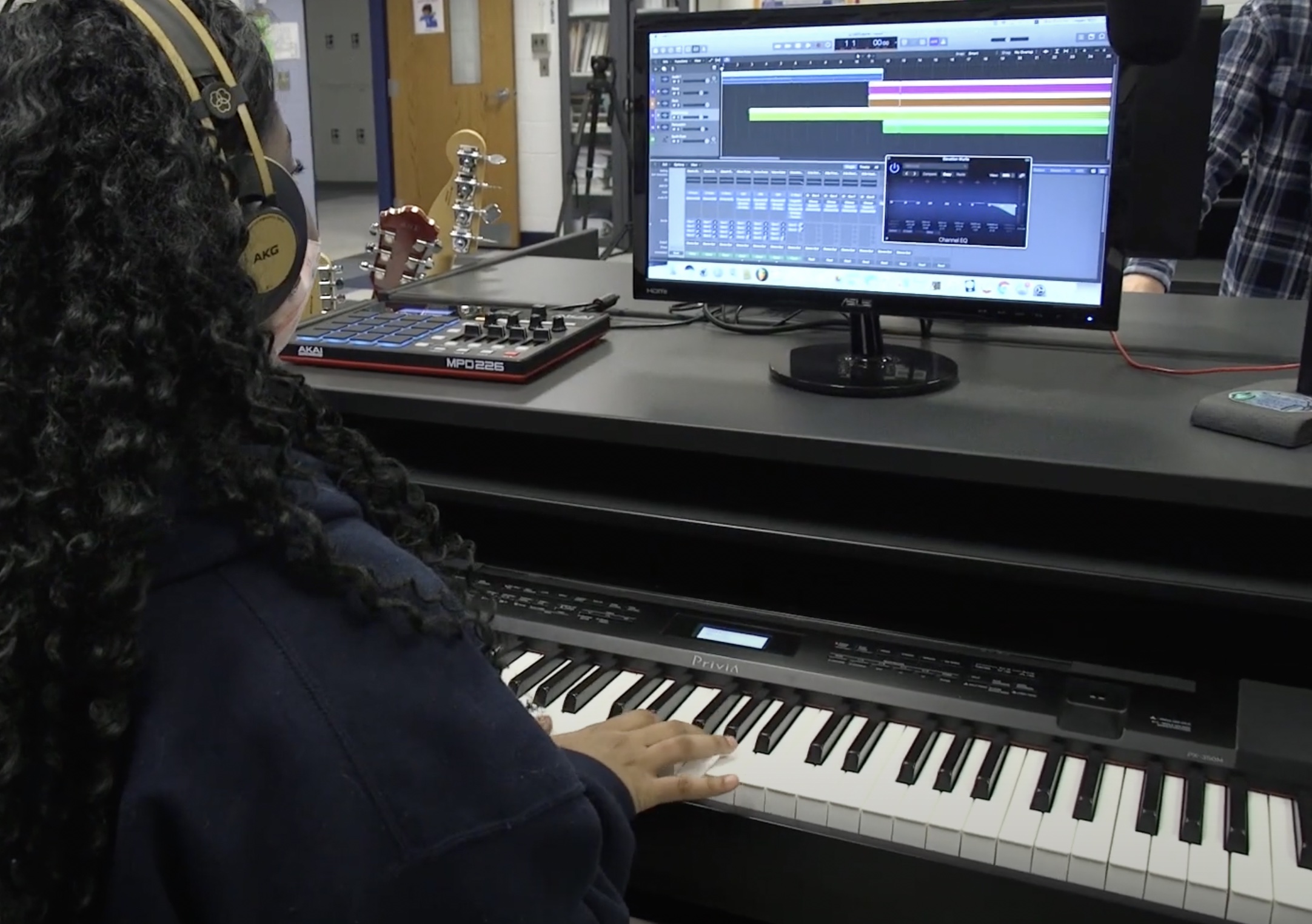 Student playing on keyboard in front of computer